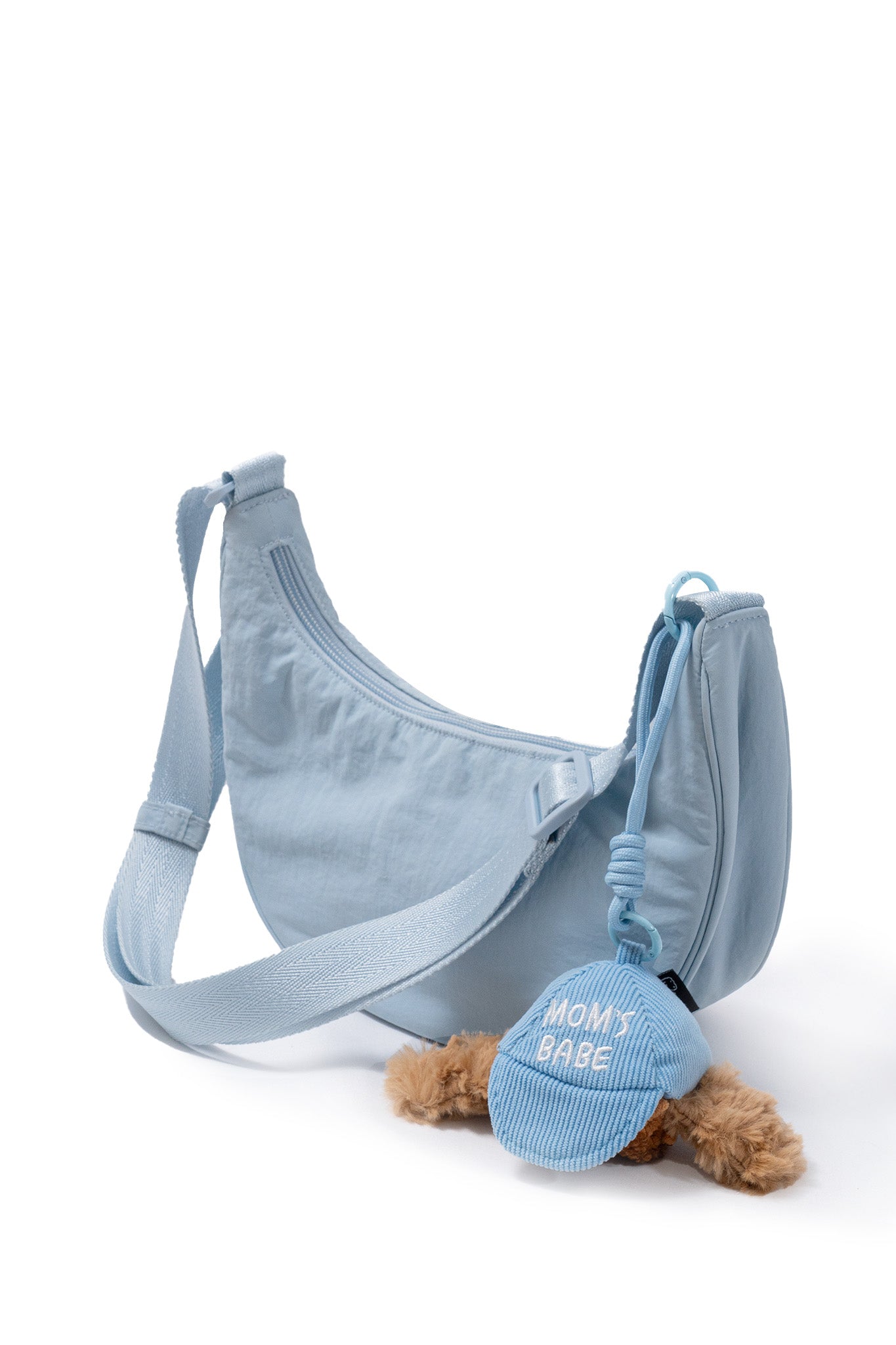 Blue Pup Charm enrichment toy clipped to a crossbody bag for portable calming play during everyday outings.
