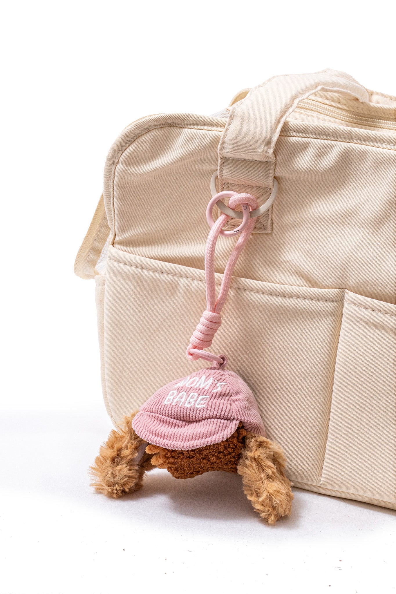 Pink CLIK Pup Charm clipped to a cream tote bag for compact, sniff-led enrichment away from home.