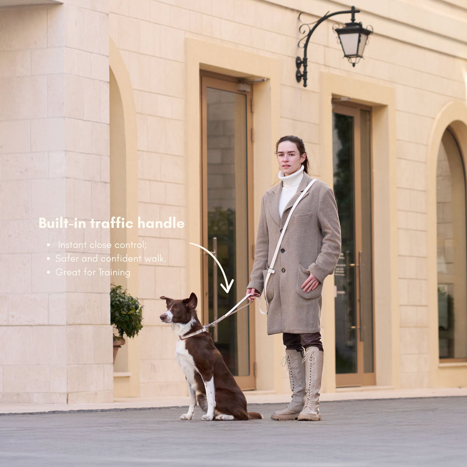 Woman holding dog on DUO Premium leash with built-in traffic handle for close control