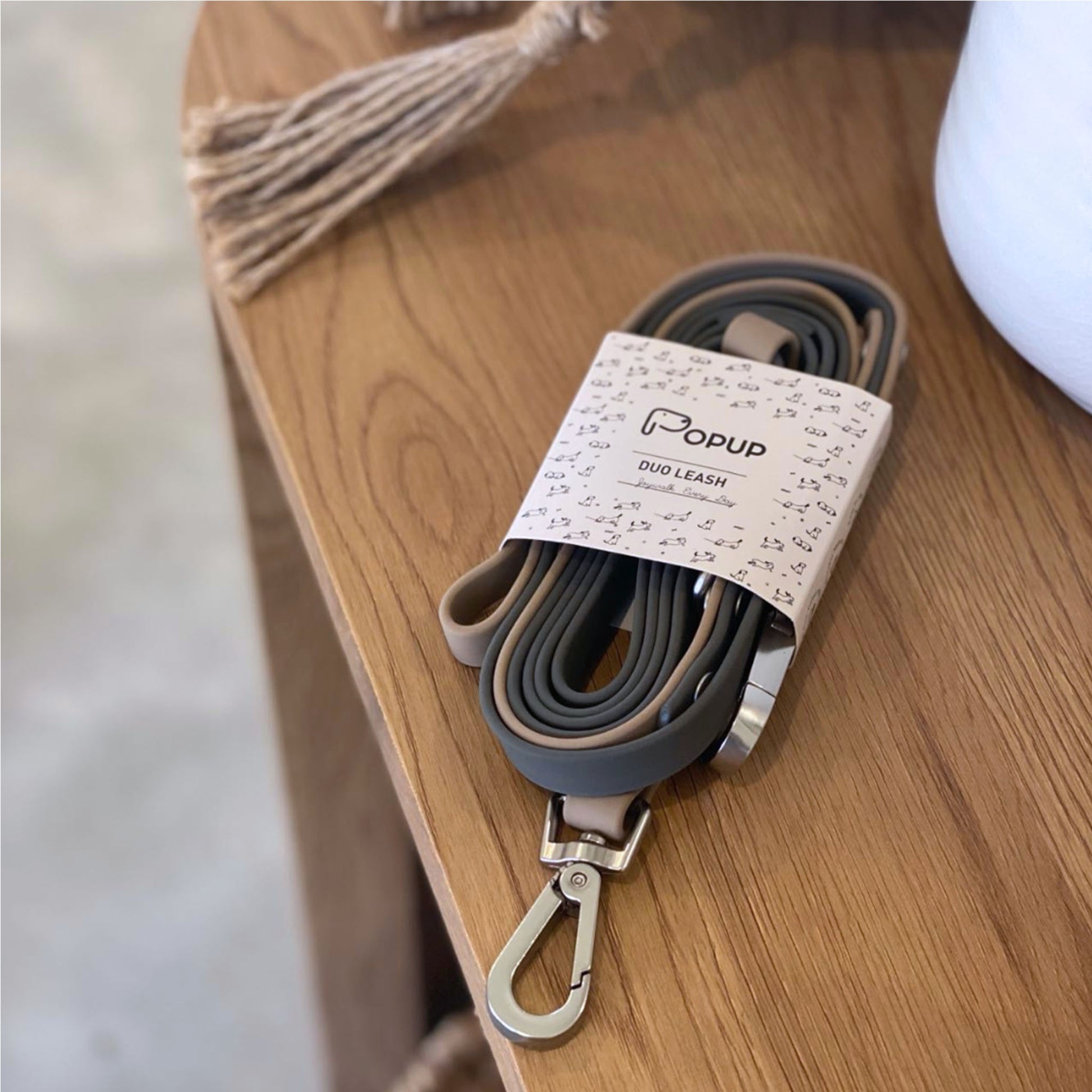 Coiled DUO Premium waterproof dog leash in branded packaging on a wooden table