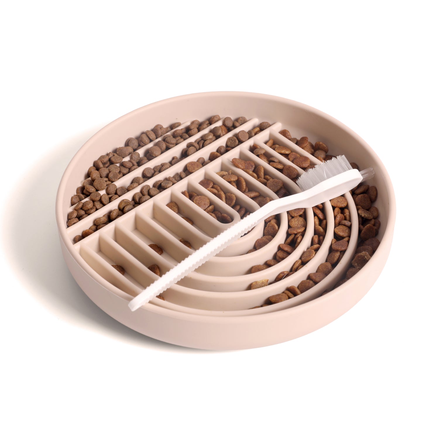 Tan silicone dog slow feeder bowl filled with kibble and cleaning brush